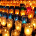 A photograph of dozens of lit candles.