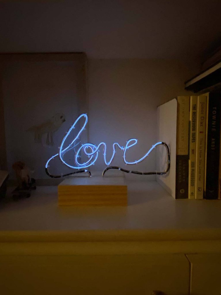 Photograph of a electroluminescent wire sculpture displaying the word "love".